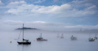Boats in foggy harbor