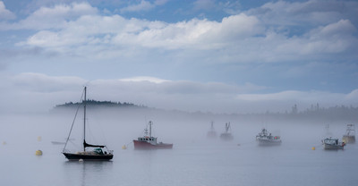 Boats in foggy harbor